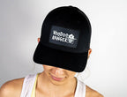 Female model wearing the hat. The front of the hat has a patch that says Voodoo Ranger and has an image of the Voodoo Ranger character's head.