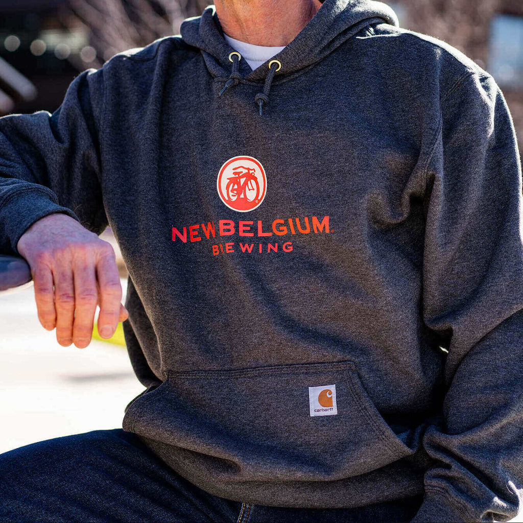Man wearing heathered gray New Belgium x Carhartt hooded sweatshirt