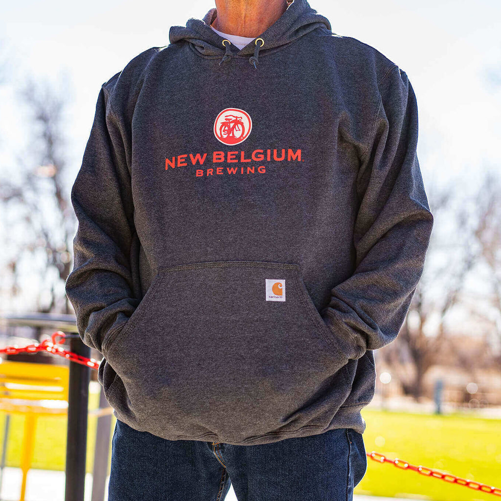 Man wearing New Belgium x Carhartt hoodie with his hands in the front pocket